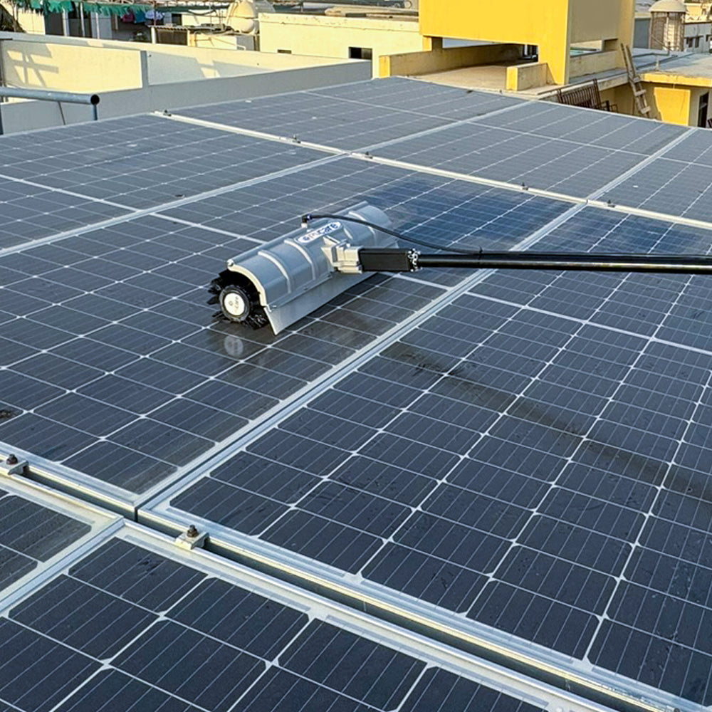 SolarCleano F1 robot viewed from the side, sweeping dust off solar panels with rotating dual brushes on tracks.