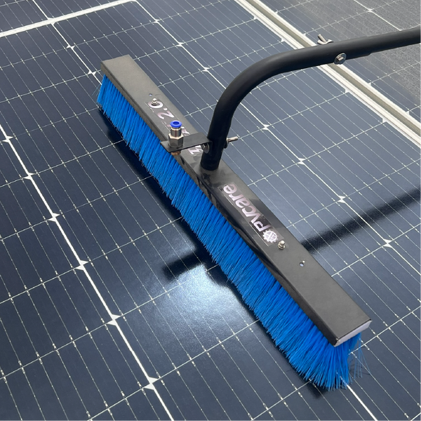 Cleaning brush with blue bristles on a solar panel